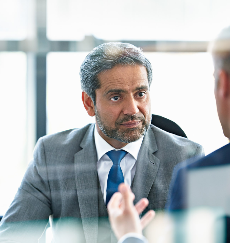 Image of male healthcare professional having conversation at an office table.