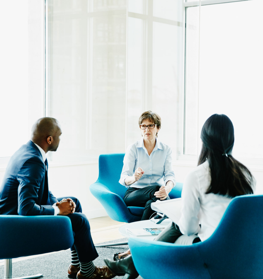 Image of diverse healthcare professionals sitting in an office mid-conversation.