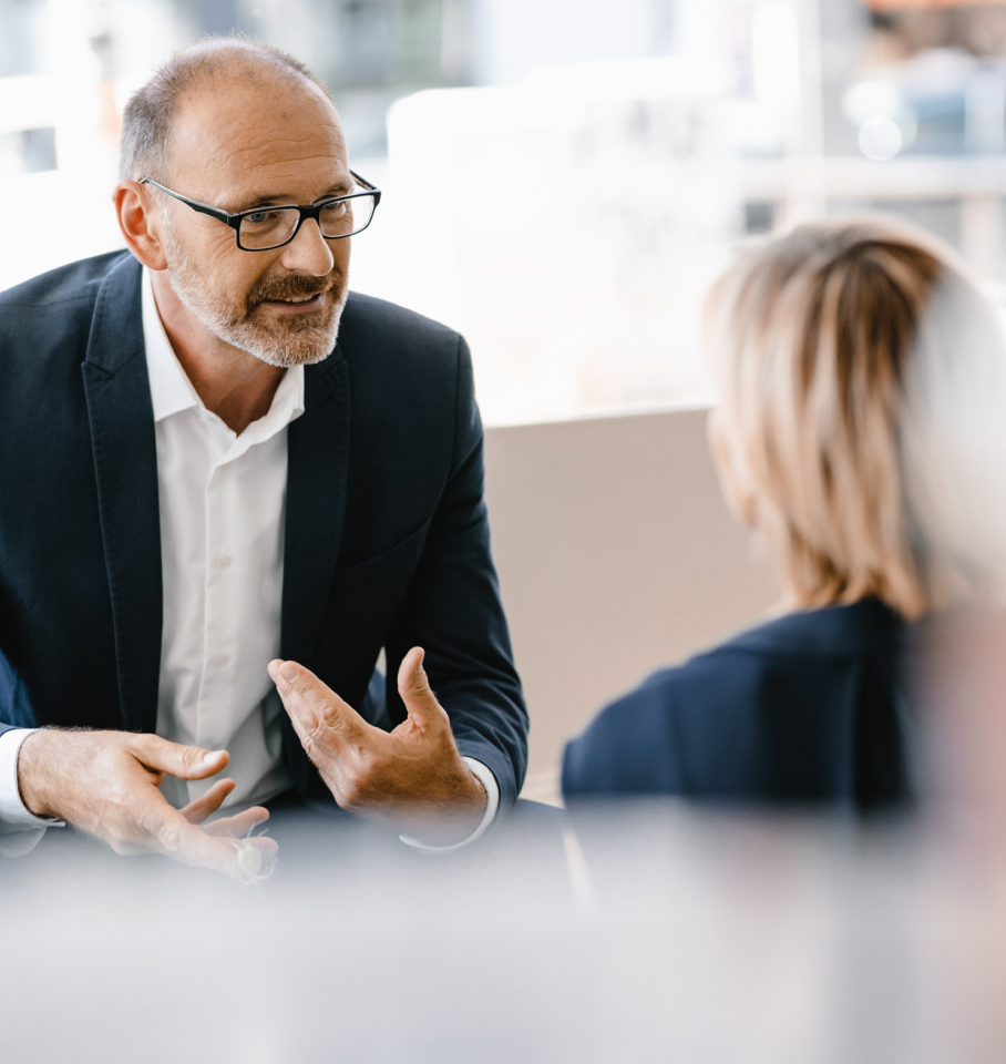 Image of a male and female healthcare professional having a conversation in an office.