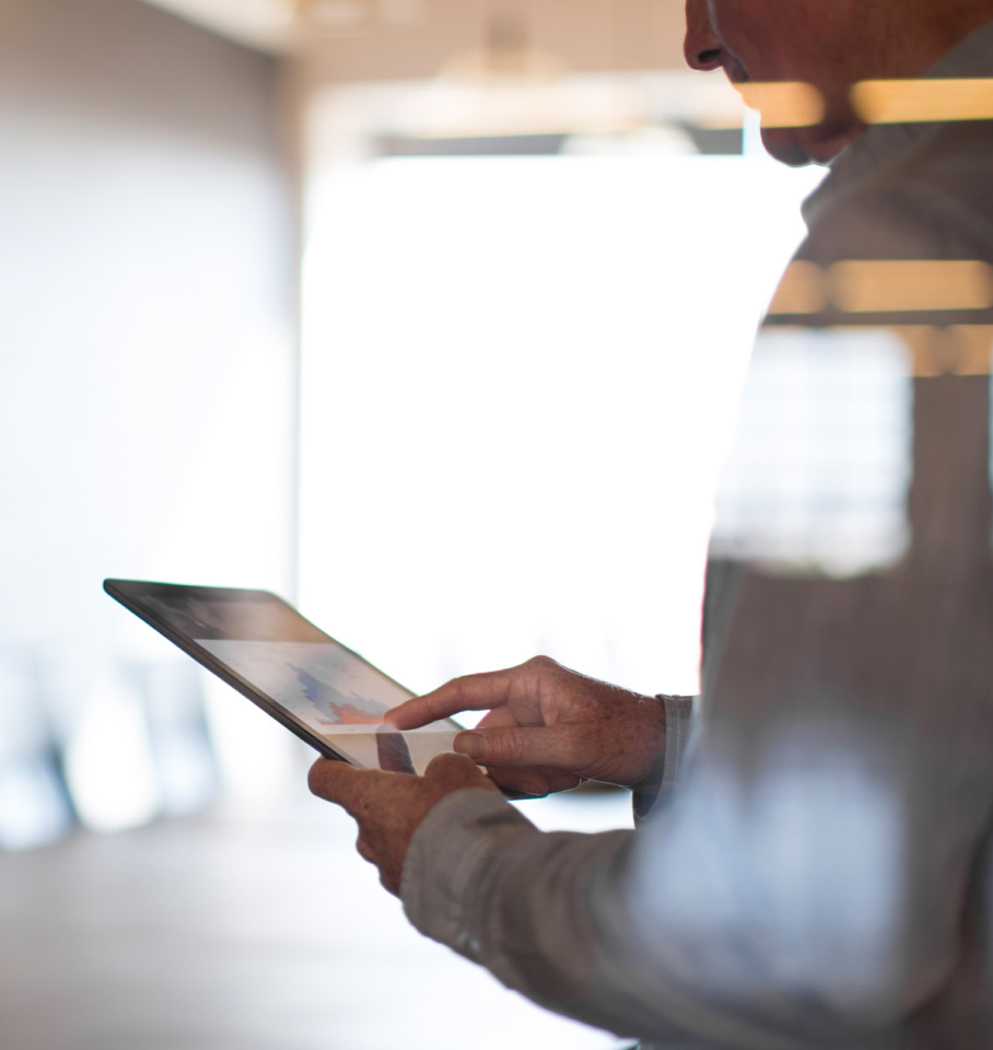 Image of male, facing away, working on a tablet.